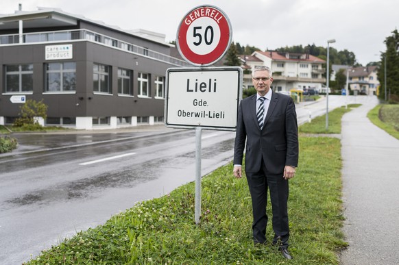 Andreas Glarner, Gemeindeammann Oberwil-Lieli, posiert eingangs Dorf Lieli vor der Ortstafel in Oberwil-Lieli, Kanton Aargau, am Mittwoch, 23. September 2015. Im Hintergrund links das Gebaeude seines  ...