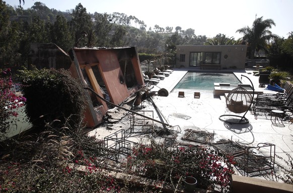 epa07161370 A property near the address of US singer Miley Cyrus lies partially in ruins as the Woosley Fire continues to burn in Malibu, California, USA, 12 November 2018. Fires across California fue ...