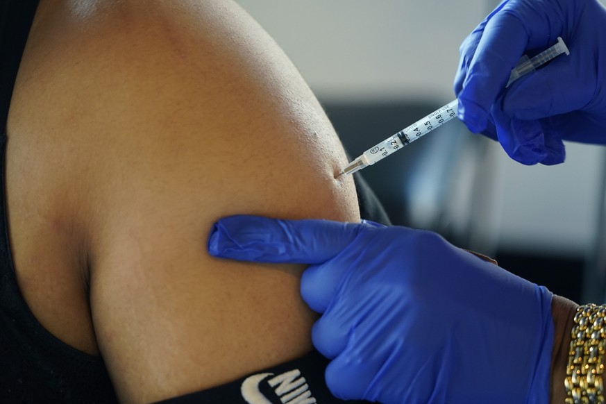 FILE - A Jackson, Miss., resident receives a Pfizer booster shot from a nurse at a vaccination site Feb. 8, 2022. The Biden administration hopes to make getting a COVID-19 booster as routine as going  ...