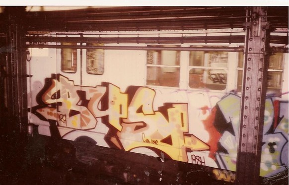 Ein Graffiti an einer New Yorker U-Bahn, aufgenommen im Jahr 1984. Wie die meisten seiner Art besteht es aus einer unentschlüsselbaren Folge von Zahlen und Buchstaben.&nbsp;