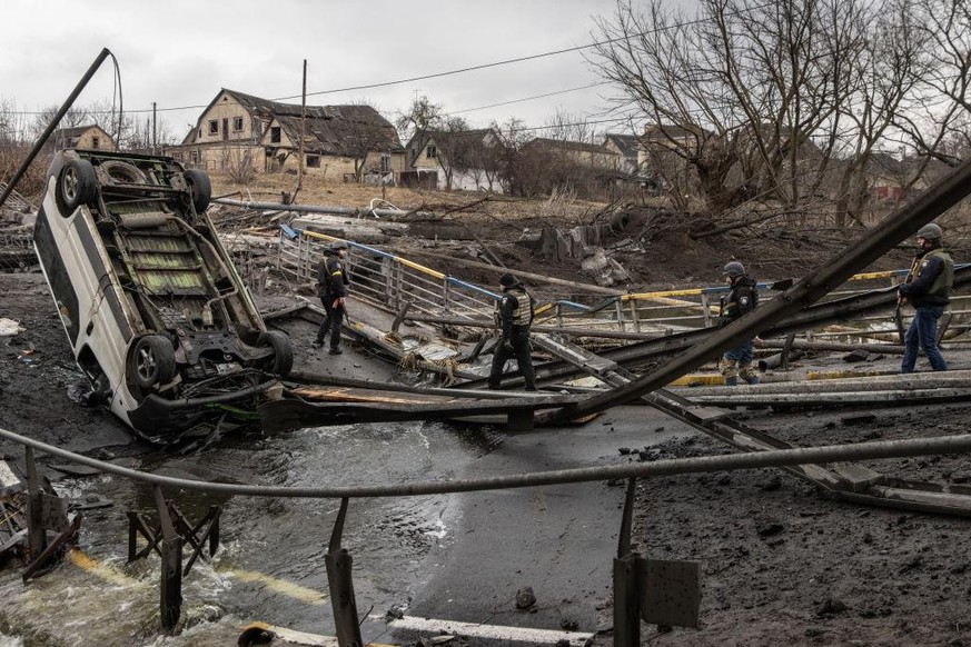 IRPIN, UKRAINE - MARCH 03: Members of the Ukrainian military walk across a destroyed bridge near the frontline amid fighting in Bucha and Irpin on March 03, 2022 in Irpin, Ukraine. Russia continues as ...