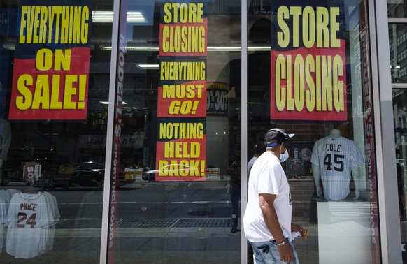 epa08448533 A man walks past a store with closing signs in the window in New York, New York, USA, 27 May 2020. Restrictions requiring the shut down of all non-essential businesses are currently in pla ...