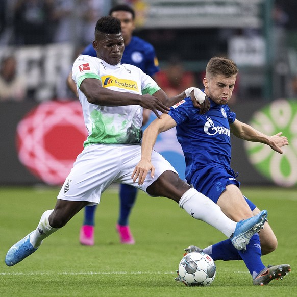 Moenchengladbach&#039;s Breel Embolo, left, and Schalke&#039;s Jonjoe Kenny fight for the ball during the Bundesliga soccer match between Moenchengladbach and Schalke in Moenchengladbach, Germany Satu ...