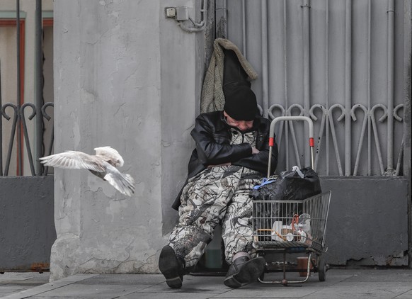 epa09930155 A homeless man sleeps in the center of Moscow, Russia, 06 May 2022. EPA/YURI KOCHETKOV
