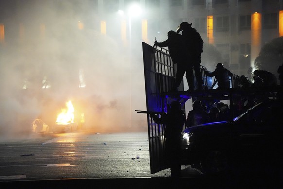 A police car on fire as riot police prepare to stop protesters in the center of Almaty, Kazakhstan, Wednesday, Jan. 5, 2022. Demonstrators denouncing the doubling of prices for liquefied gas have clas ...