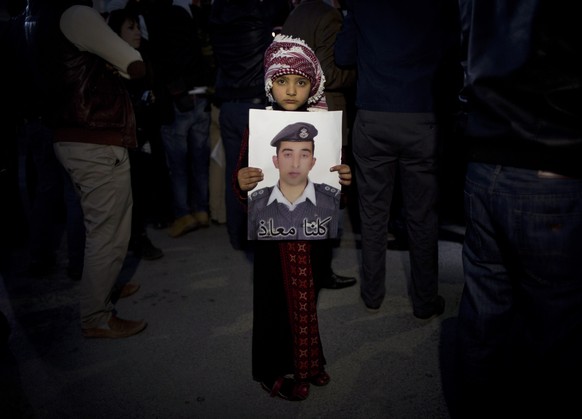 Ein jordanisches Kind hält ein Plakat mit dem jordanischen Kampfpiloten Maas al-Kassabeh hoch, der von den Dschihadisten gekidnappt wurde.