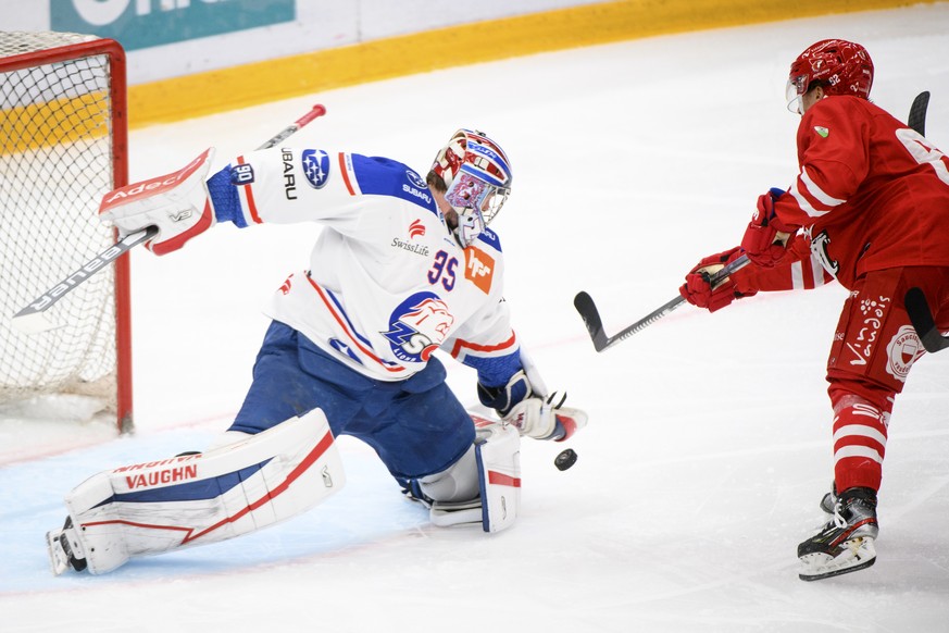 Le gardien zuerichois Ludovic Waeber, gauche, lutte pour le puck avec l&#039;attaquant lausannois Denis Malgin, droite, lors du 5eme match de quart de finale playoff du championnat suisse de hockey su ...