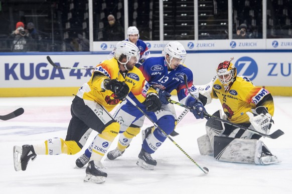 Zuerichs Justin Sigrist, links, kaempft um den Puck gegen Berns Torhueter Tomi Karhunen, rechts, im Final des Swiss Ice Hockey Cups 2020/21 zwischen den ZSC Lions und dem SC Bern am Sonntag, 28. Febru ...