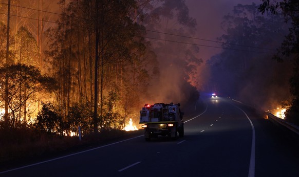 epa07990204 Fire burns alongside the Pacific Highway, north of Nabiac, New South Wales, Australia, 12 November 2019. At least 60 fires are burning across New South Wales, with a fire front of approxim ...