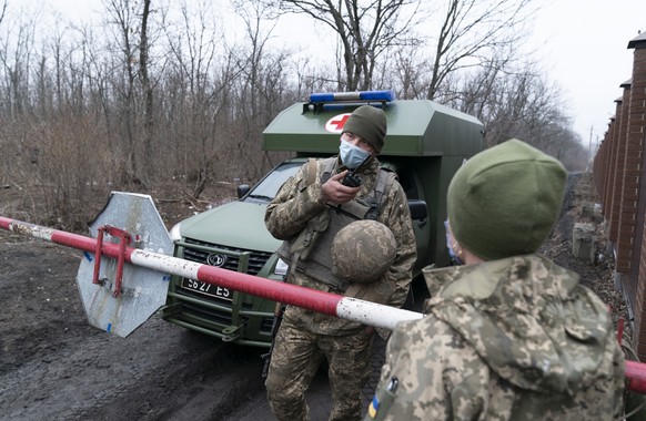 A Ukrainian serviceman speaks on a on the walkie-talkie as military medics arrive at a military base to vaccinate troops near the front-line town of Krasnohorivka, eastern Ukraine, Friday, March 5, 20 ...