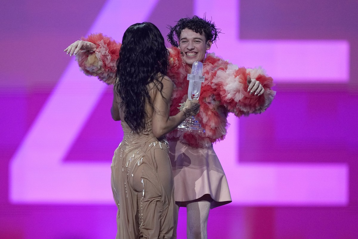 Nemo of Switzerland, who performed the song The Code, receives the trophy from last year's winner Loreen of Sweden after winning the Grand Final of the Eurovision Song Contest in Malmo, Sweden, S ...