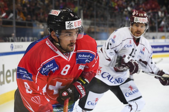 Team Suisse player Vincent Praplan, right, challenges for the puck with Riga&#039;s Anssi Salmela, during the game between Team Suisse and Dinamo Riga at the 91th Spengler Cup hockey tournament in Dav ...