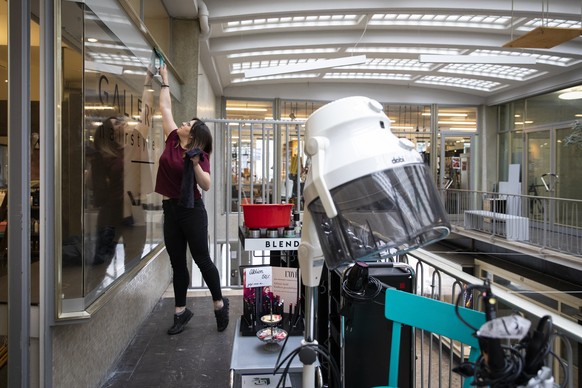 Eine Angestellte des Coiffeursalons Gallery Hairstyle reinigt die Fenster des Coiffeursalons, am Dienstag, 21. April 2020 in Bern. Coiffeure duerfen ihre Geschaefte ab dem 27.4.2020 wieder oeffnen. (K ...