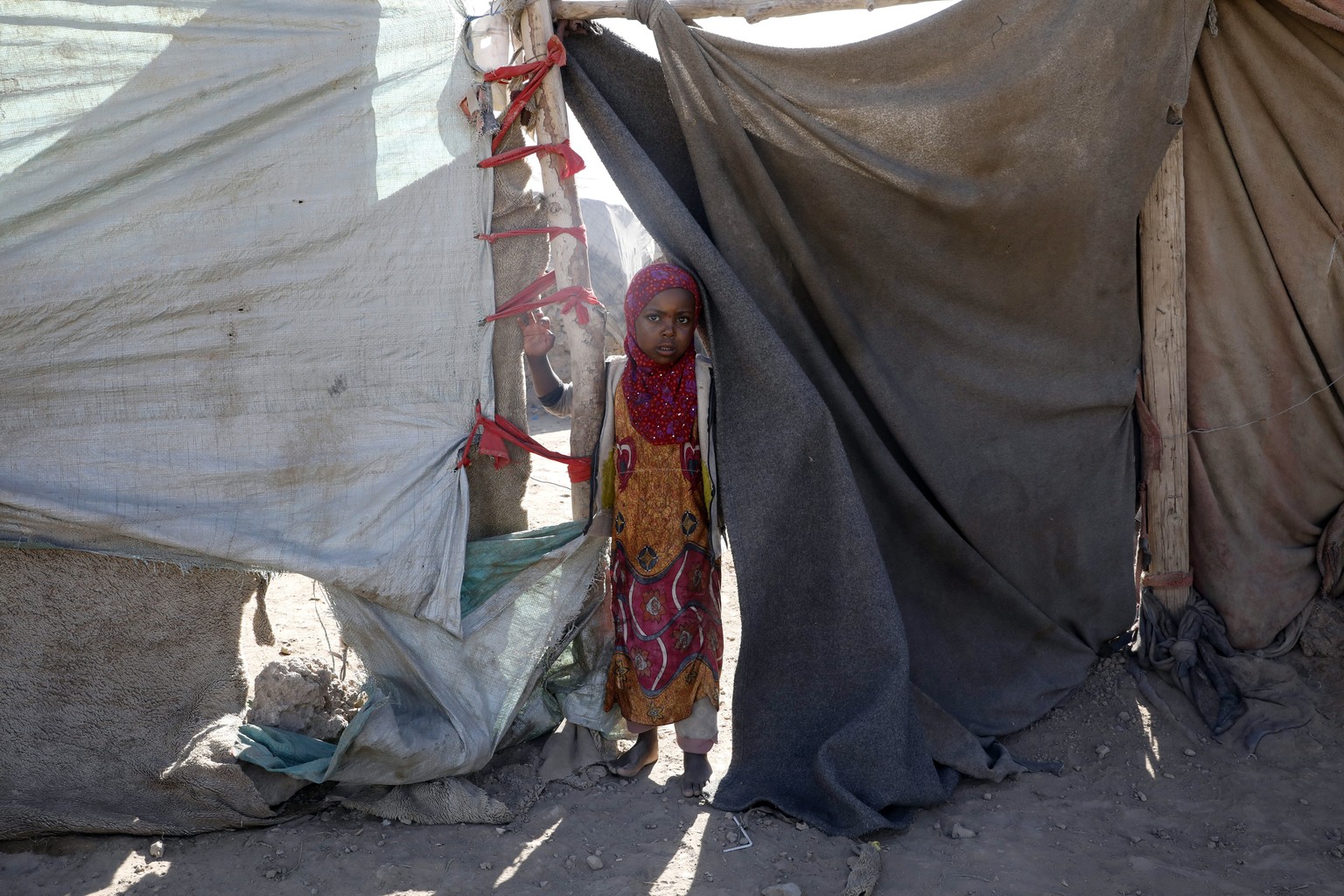 A Yemeni child stands next to his family's shelter at an internally displaced persons camp on the outskirts of Sana'a, Yemen, December 5, 2022.
