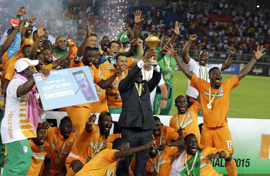 FILE - In this Sunday, Feb. 8, 2015 file photo, Ivory Coast players celebrate with the trophy after winning their African Cup of Nations final soccer match against Ghana in Bata, Equatorial Guinea. Th ...