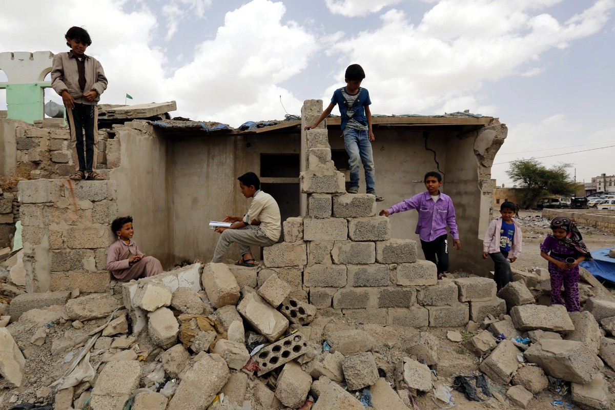 epa05870207 Yemenis stand over the rubble of buildings allegedly destroyed by Saudi-led airstrikes on buildings two years ago, in Sana'a, Yemen, 25 March 2017. On 26 March 2015, the Saudi-led coa ...