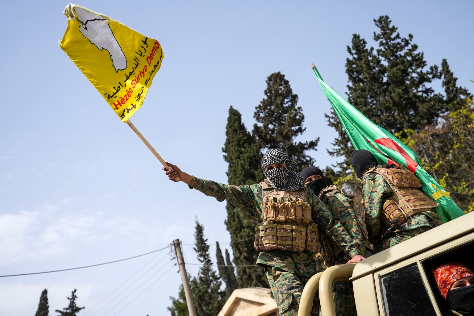 epaselect epa12020615 Members of the Syrian Democratic Forces (SDF) wave flags while departing the city of Aleppo, as part of an agreement with the Syrian government, in Aleppo, Syria, 09 April 2025.  ...
