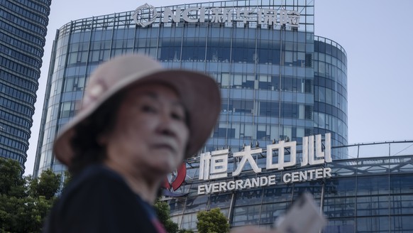 epa09479218 A woman walks past the Evergrande Center in Shanghai, China, 21 September 2021. Evergrande Group is China?s real estate conglomerate and the world?s most indebted property developer. Stock ...