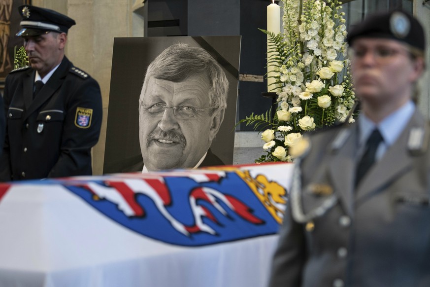 FILE-In this June 13, 2019 file photo a picture of Walter Luebcke stands behind his coffin during the funeral service in Kassel, Germany. German authorities say they have arrested a 45-year-old man in ...