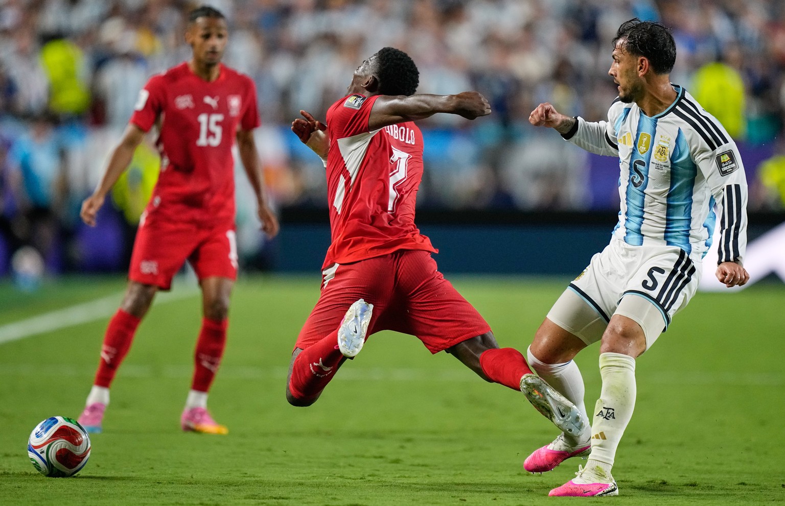 Switzerland's Breel Embolo (7) reacts in a challenge from Argentina's Leandro Paredes (5) during the World Cup quarterfinal soccer match between Argentina and Switzerland in Kansas City, Mo. ...