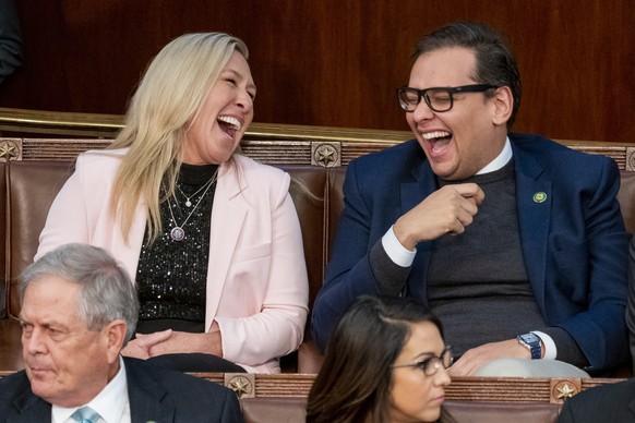 epa10391188 Georgia Republican Representative Marjorie Taylor Greene (L) laughs with New York Republican Representative George Santos (R) in the House Chamber on the third day of ...
