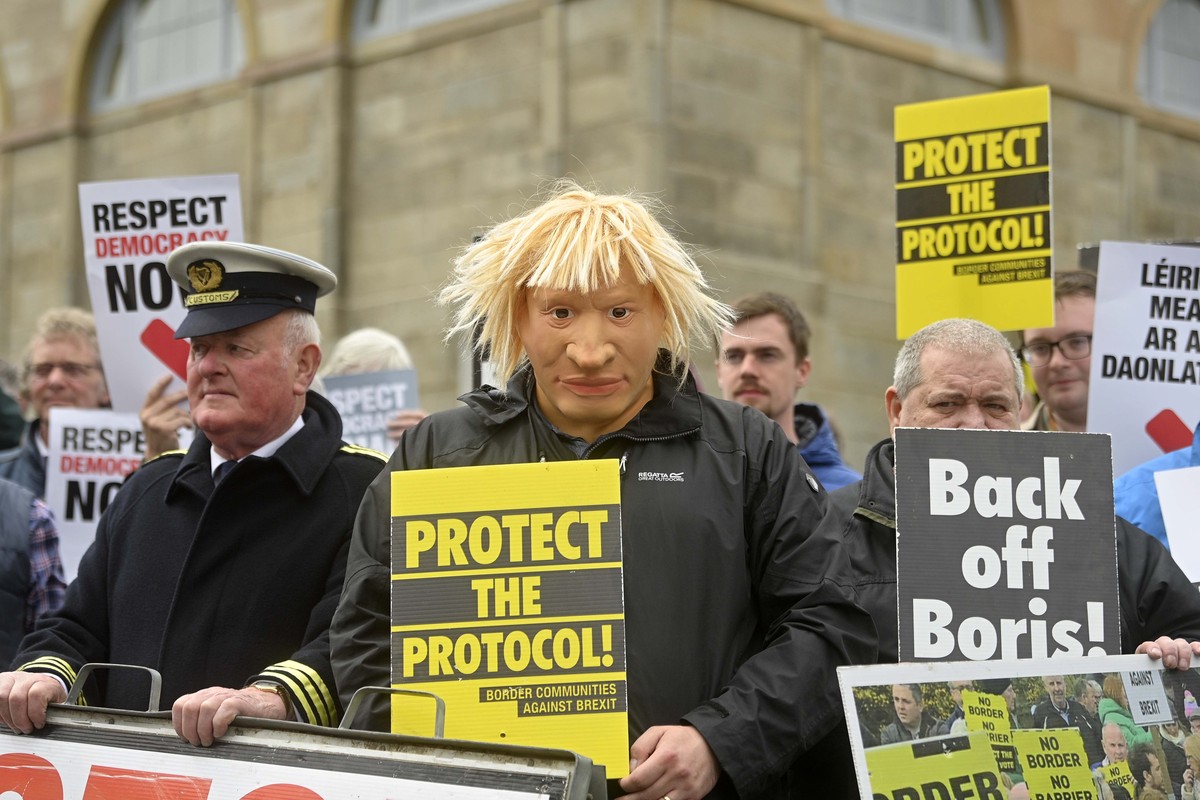 epa09950749 A campaigner from "Time for Truth" wears a mask resembling British Prime Minister Johnson, as he and legacy victims wait for the arrival of the British Prime Minister at Hillsbor ...