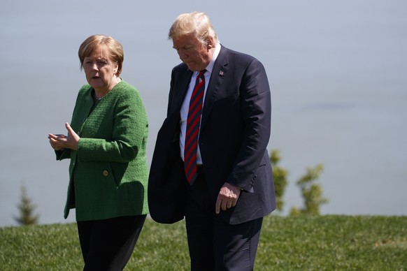 President Donald Trump, right, talks with German Chancellor Angela Merkel after the family photo during the G7 Summit, Friday, June 8, 2018, in Charlevoix, Canada. (AP Photo/Evan Vucci)