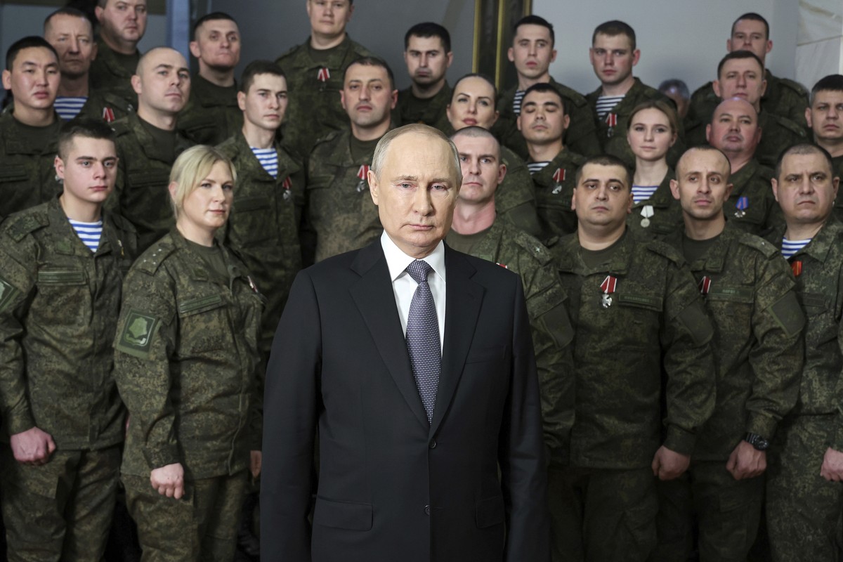 President Vladimir Putin speaks in his annual televised New Year's message after a ceremony during a visit to the headquarters of the Southern Military District, at an unknown location in Russia, ...