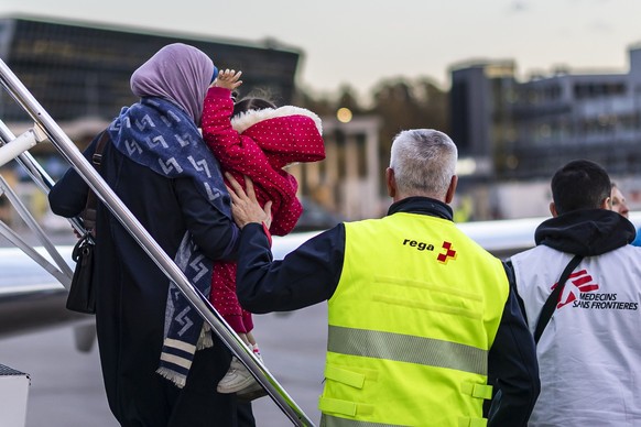 An injured child and his mother are taken to an ambulance after landing at Zurich Airport, Switzerland, on Friday, October 24, 2025. As part of a humanitarian operation, Switzerland has evacuated a fi ...