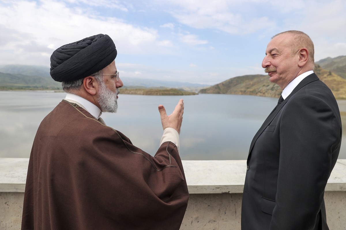 In this photo released by the Iranian Presidency Office, President Ebrahim Raisi, left, speaks with his Azeri counterpart Ilham Aliyev on the inauguration of dam of Qiz Qalasi, or Castel of Girl in Az ...