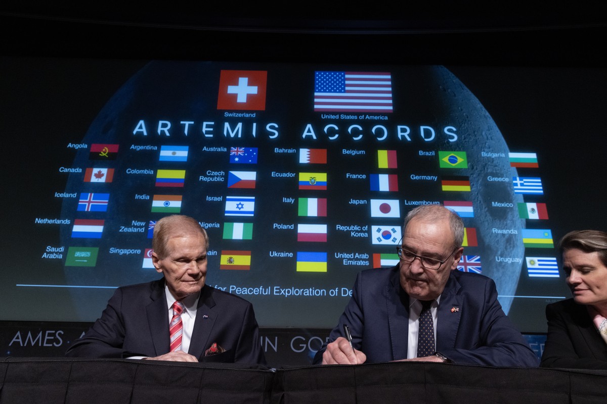 Le conseiller fédéral suisse Guy Parmelin (centre) signe les accords d'Artemis aux côtés de l'administrateur de la NASA Bill Nelson.