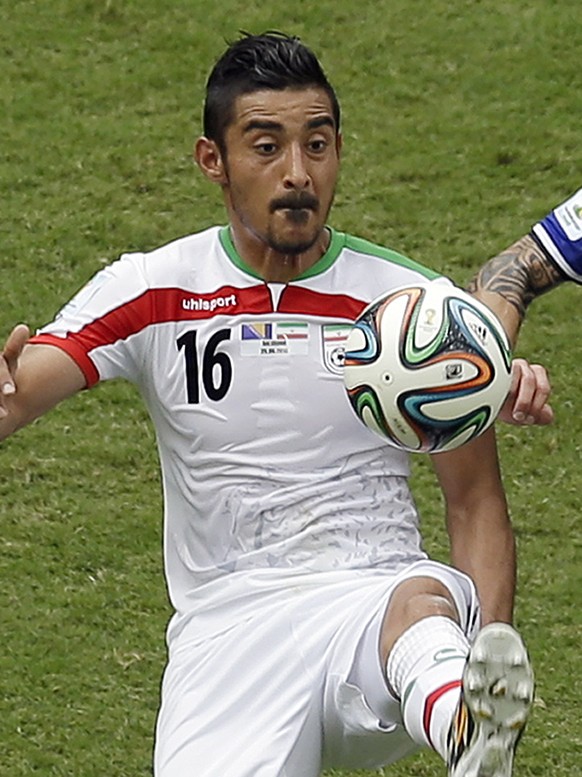 Iran forward Reza Ghoochannejhad, left, kicks the ball away from Bosnia defender Muhamed Besicduring the second half of a group F World Cup soccer match at the Arena Fonte Nova in Salvador, Brazil, We ...