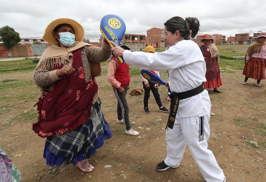 epa09793990 Bolivian Laura Roca (R) from Warmi Power, conducts a self-defense workshop in the Villa Mercedes neighborhood in El Alto, Bolivia, 18 February 2022 (Issued 01 March 2022). Taekwondo techni ...