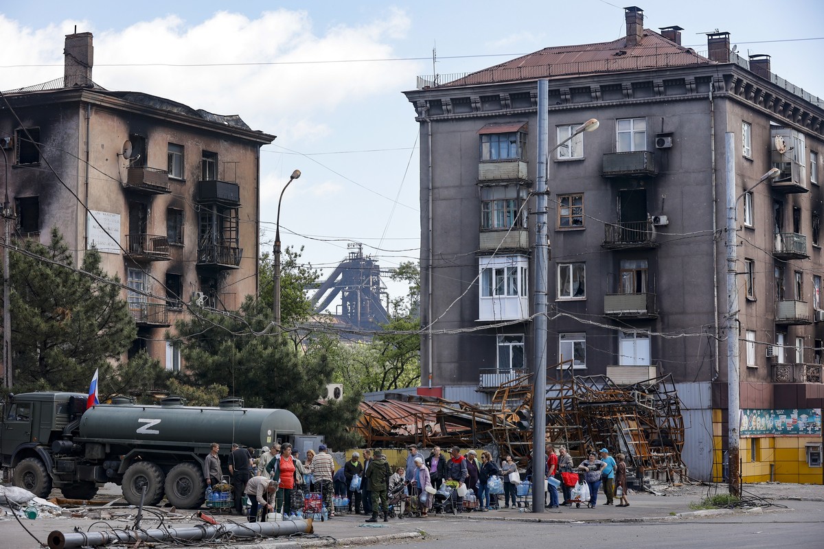 Local civilians gather to receive pure water distributed by Russian Emergency Situations Ministry in Mariupol, in territory under the government of the Donetsk People's Republic, eastern Ukraine, ...