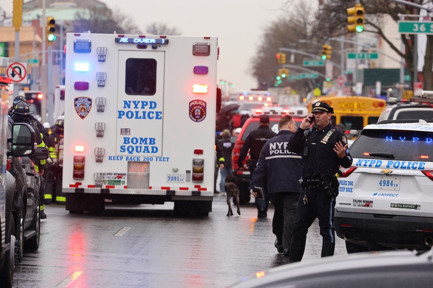epa09886027 New York City Police and New York City Fire Department officials on the scene of a reported multiple shooting at a New York City Subway station in the Brooklyn borough of New York, New Yor ...