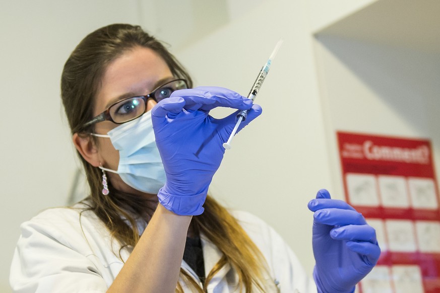 A nurse holds a dose of experimental vaccine &quot;cAd3-EBOZ Lau&quot; at the Lausanne University Hospital (CHUV) in Lausanne, Switzerland, Tuesday, November 4, 2014. Swissmedic approved the applicati ...
