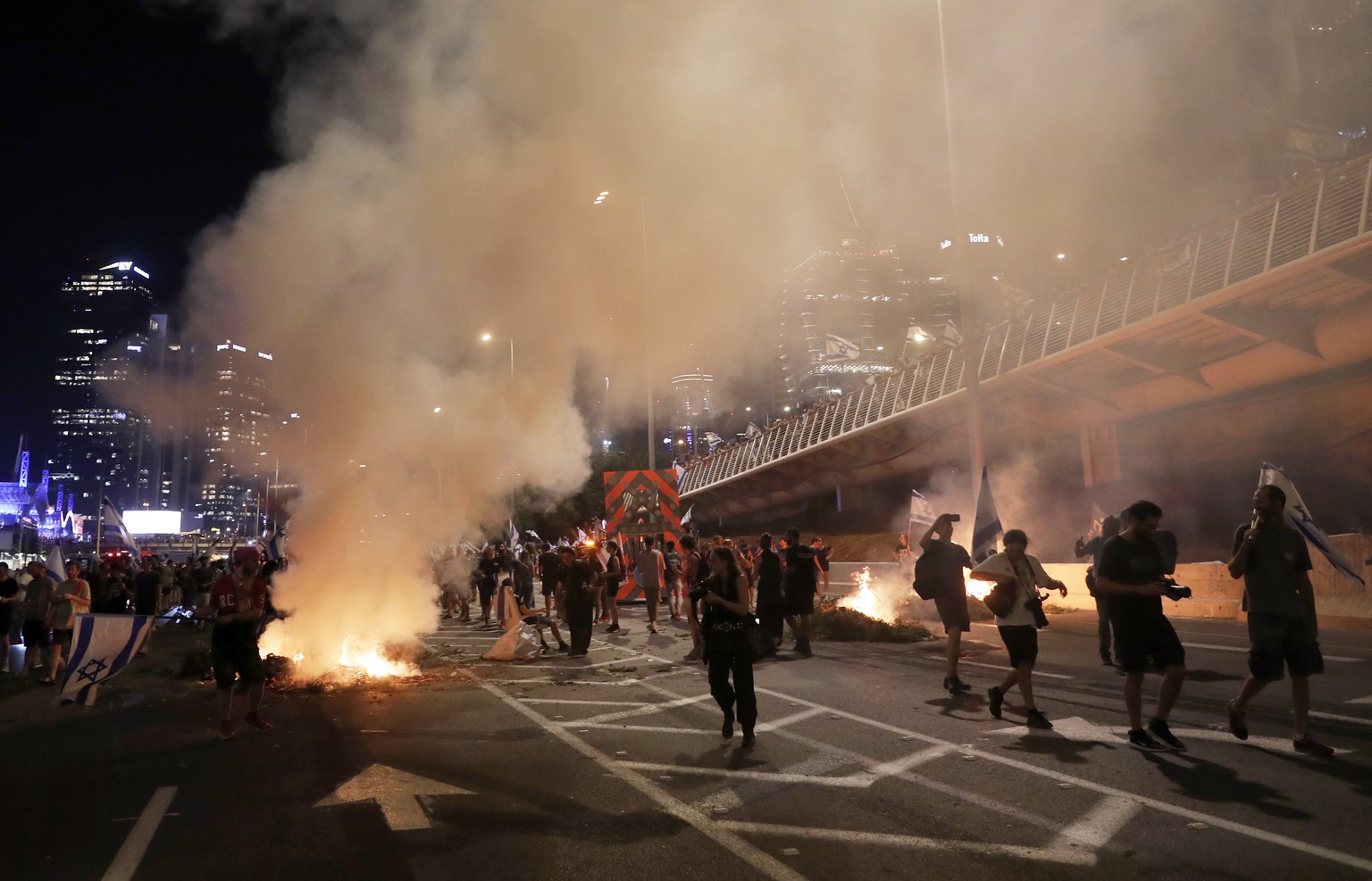 epa10758814 Anti-government protesters burn barricades as they block Ayalon highway during a protest against the Israeli justice system reform in Tel Aviv, Israel, 20 July 2023. Protesters called for  ...