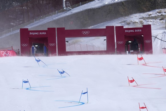 Gate flags bend in the wind after high winds caused a delay in the start of the mixed team parallel skiing event at the 2022 Winter Olympics, Saturday, Feb. 19, 2022, in the Yanqing district of Beijin ...