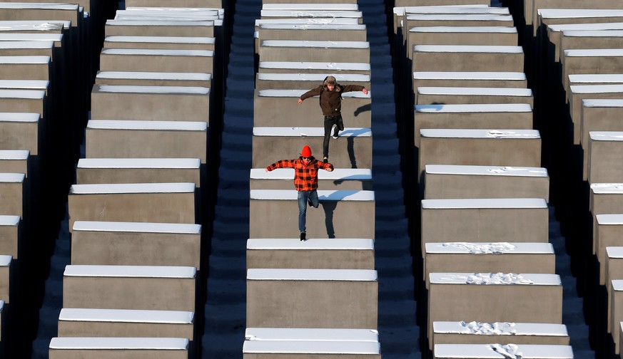 FILE PHOTO: People jump from concrete elements of the Holocaust memorial in Berlin, Germany, January 25, 2013. REUTERS/Fabrizio Bensch/File Photo