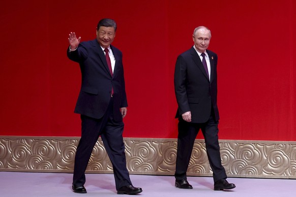Russian President Vladimir Putin, right, and Chinese President Xi Jinping leave a concert marking the 75th anniversary of the establishment of diplomatic relations between Russia and China and opening ...