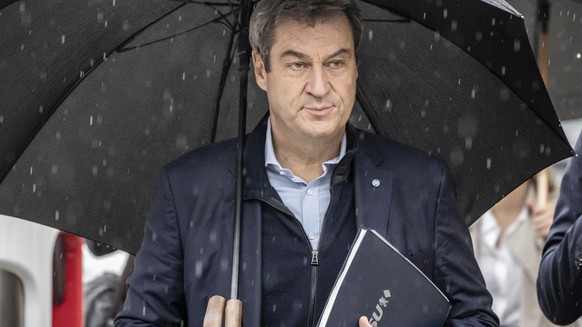 Markus Söder (CSU), Prime Minister of Bavaria and CSU chairman, arrives under an umbrella for exploratory talks between the CDU and B