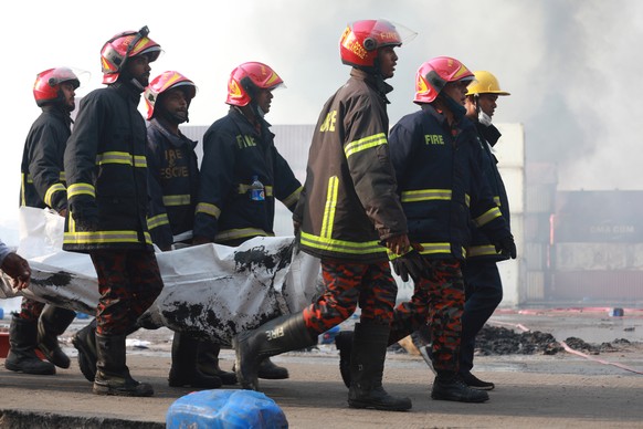 epa09996821 Firefighters shift body bags of victims of a massive fire at BM container depot in Shitalpur, Sitakunda Upazela, Chattogram, Bangladesh, 05 June 2022. At least 35 people are dead and over  ...