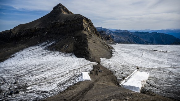Wanderer gehen am Dienstag, den 13. September 2022, auf dem Gebiet von Glacier 3000 oberhalb von Les Diablerets an der Trennung des Scex Rouge-Gletschers vom Tsanfleuron-Gletscher vorbei, wodurch der  ...