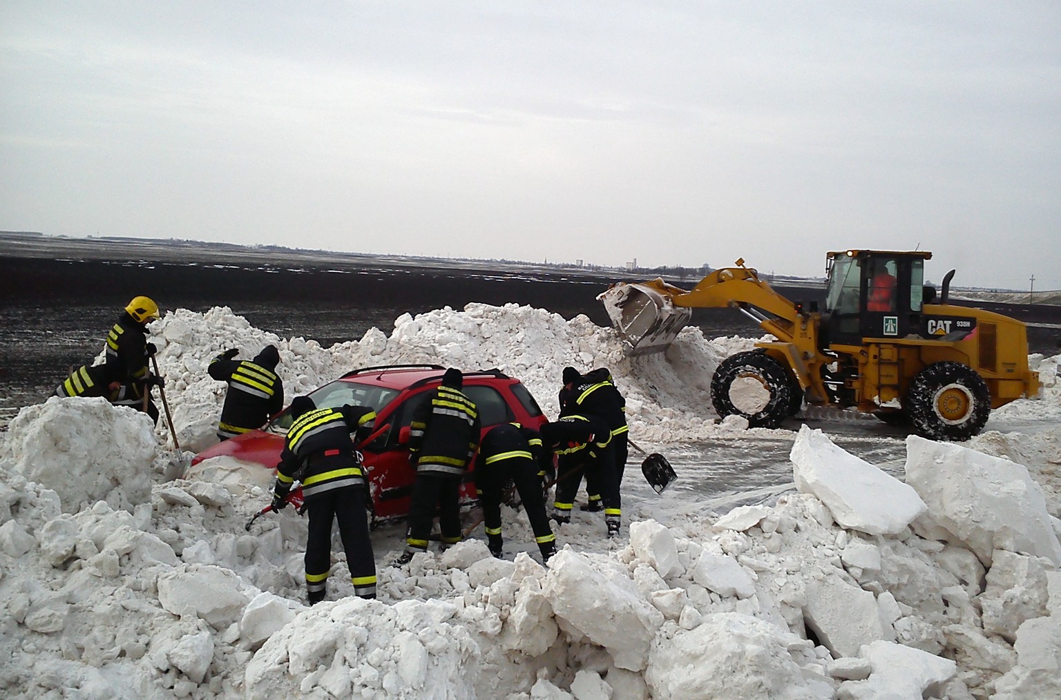 Serbische Feuerwehrleute befreien ein Auto aus dem Schneemassen.