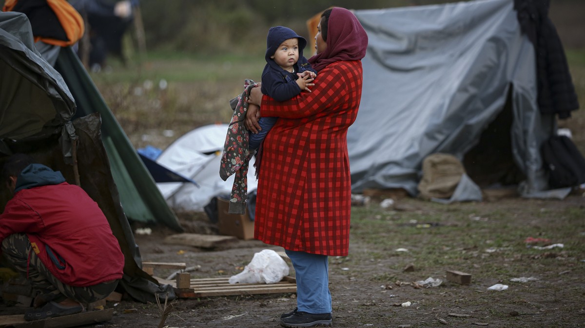 FILE - A migrant woman holds a baby at a makeshift camp housing migrants mostly from Afghanistan, in Velika Kladusa, Bosnia, on Oct. 12, 2021. German Chancellor Olaf Scholz on Thursday June 22, 2023 d ...