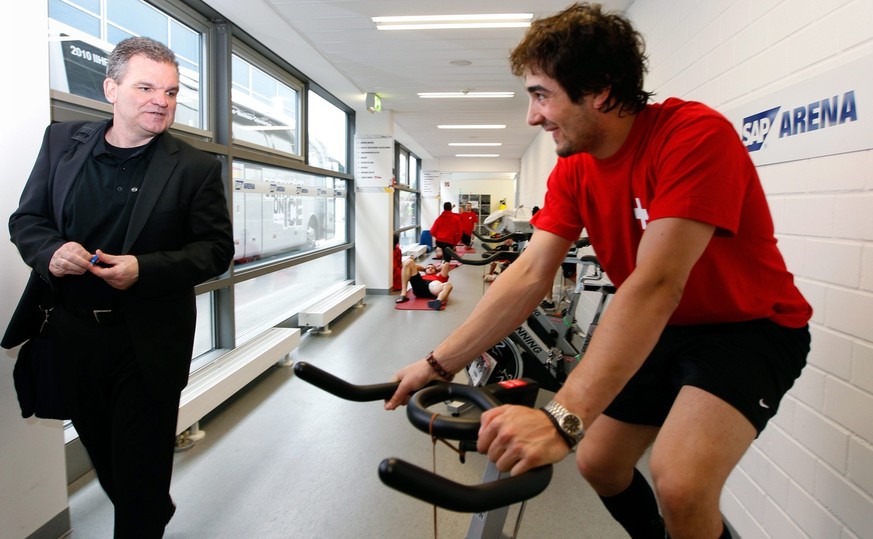 Der Schweizer Eishockey Nationalspieler Andres Ambuehl nach dem Eistraining auf dem Rad, beobachtet vom Nationaltrainer Sean Simpson, links, am Freitag, 7. Mai 2010, in der SAP Arena in Mannheim, Deut ...