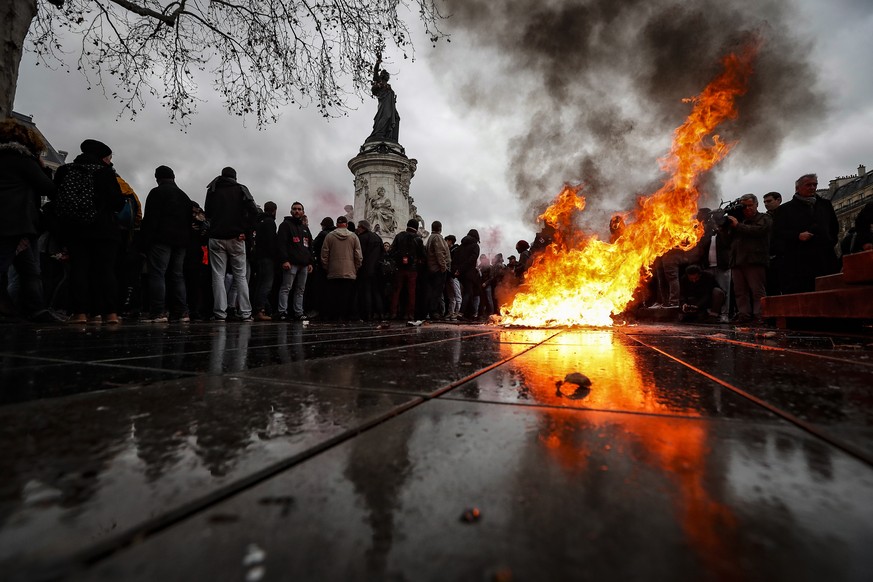 epa07214673 A trashcan burns on Place de la Republique as students demonstrate against the increase of the subscription fees for foreigners students, in Paris, France, 07 December 2018. This movement  ...