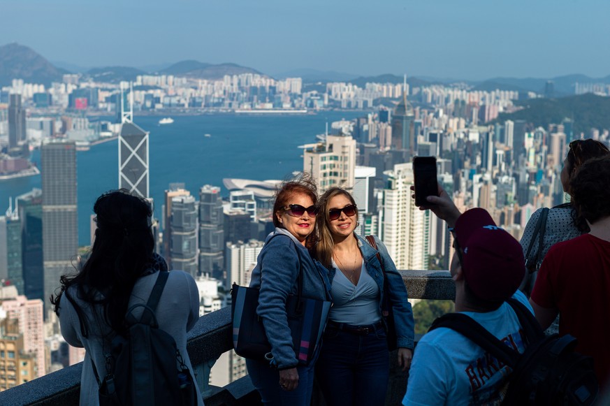 epa08111694 Tourists take pictures on a panoramic viewing deck on Victoria Peak in Hong Kong, China, 08 January 2019. According to recent reports, tourist arrivals in Hong Kong fell 56 percent year on ...