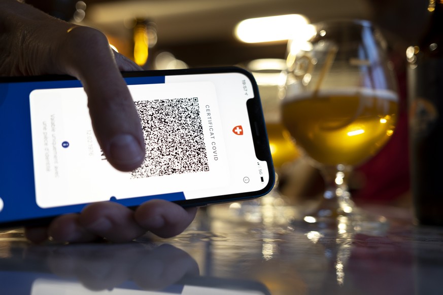 Une personne tient dans sa main un smartphone avec l&#039;application Certifact Covid suisse dans un restaurant ce vendredi 10 septembre 2021 a Rances dans le canton de Vaud. Des ce lundi 13 septembre ...