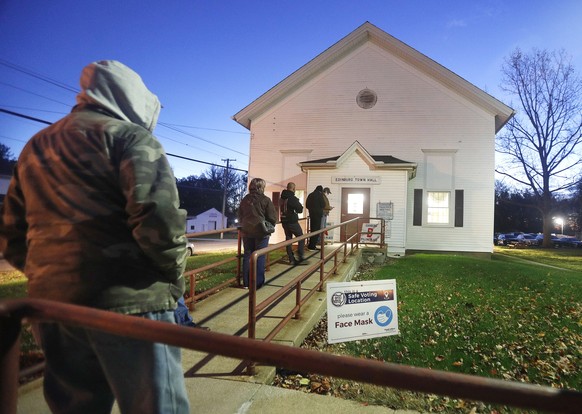 epa08795045 Voters wait in line before dawn and before the doors open at a polling location at the Edinburg Town Hall in Edinburg, Ohio, USA, 03 November 2020. Americans vote on Election Day to choose ...